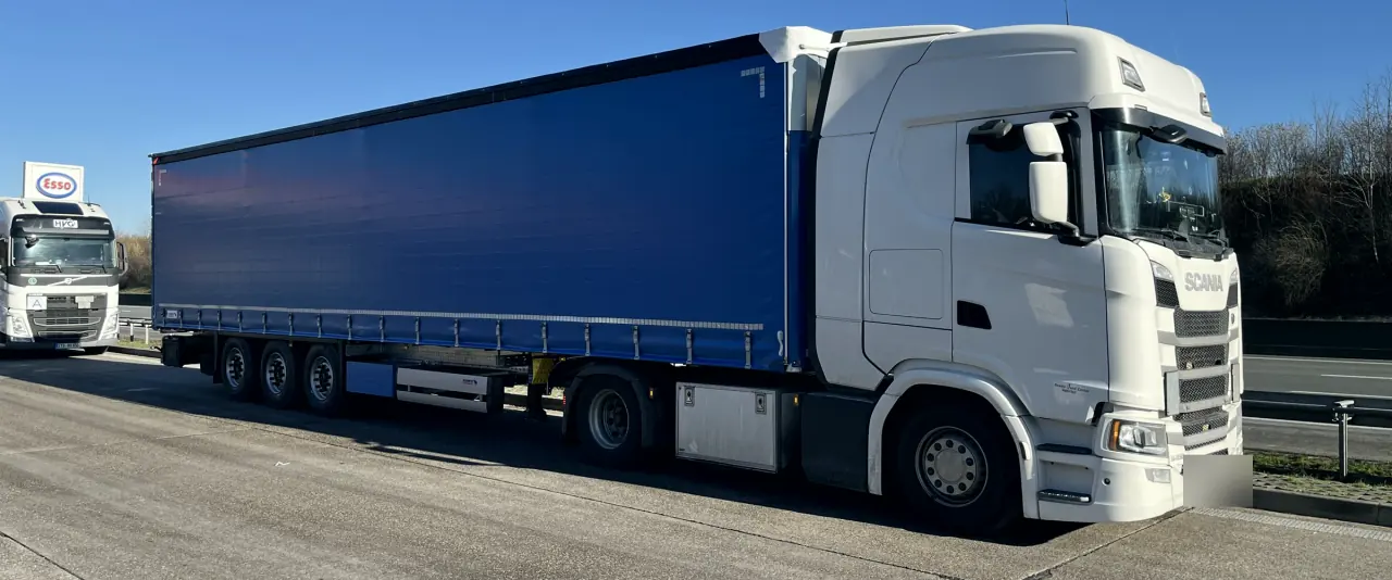 Zestaw z niebieską plandeką na parkingu przy autostradzie